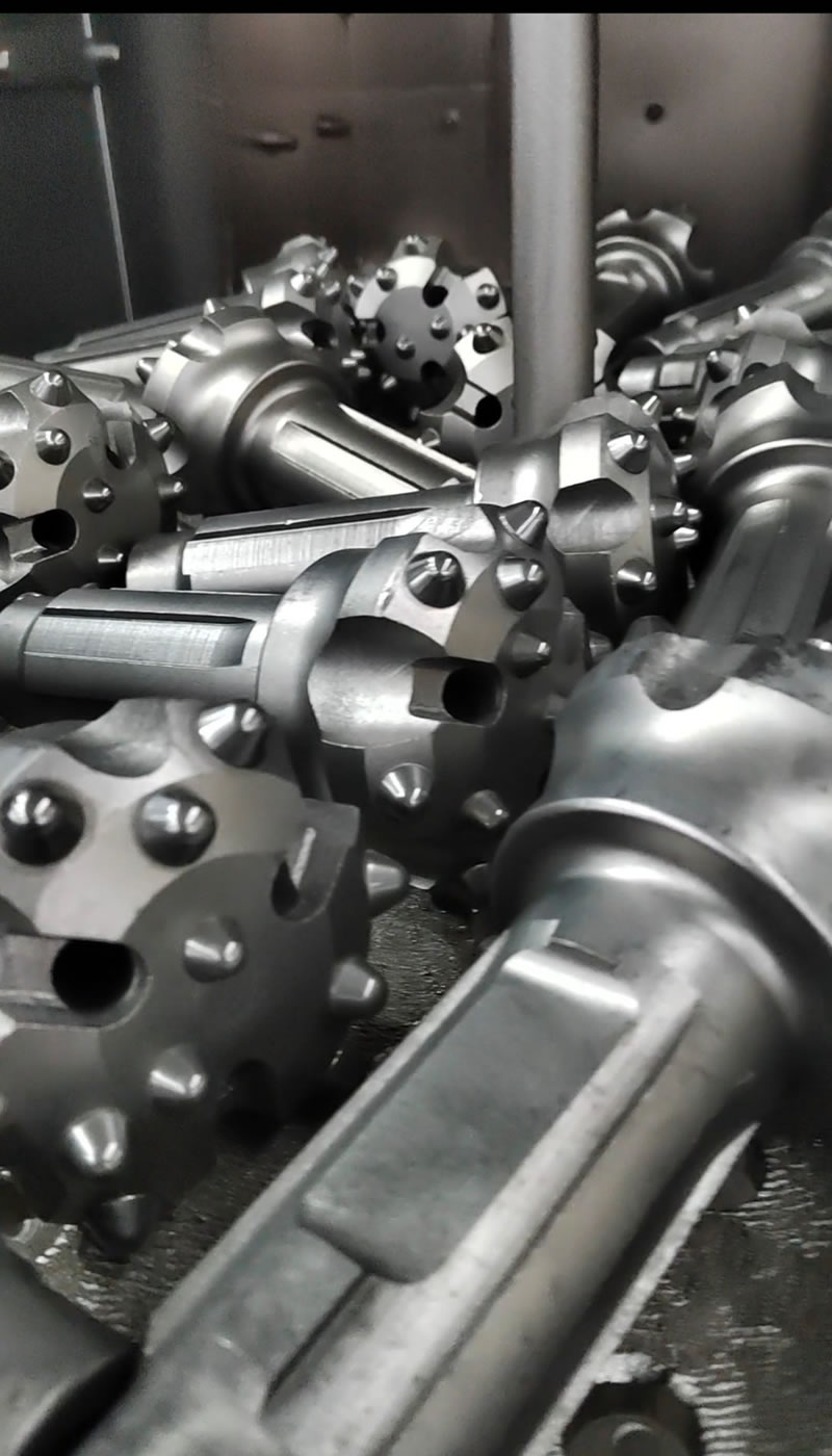 Surface shot blasting treatment for dth rock drilling bits